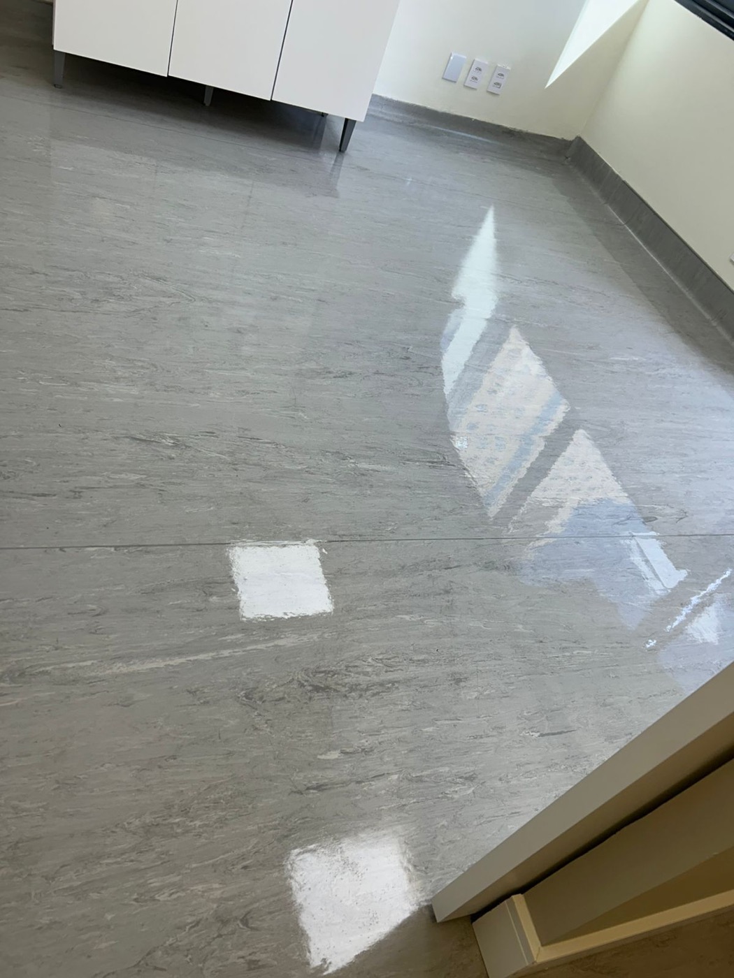 Piso cinza polido com brilho em ambiente corporativo